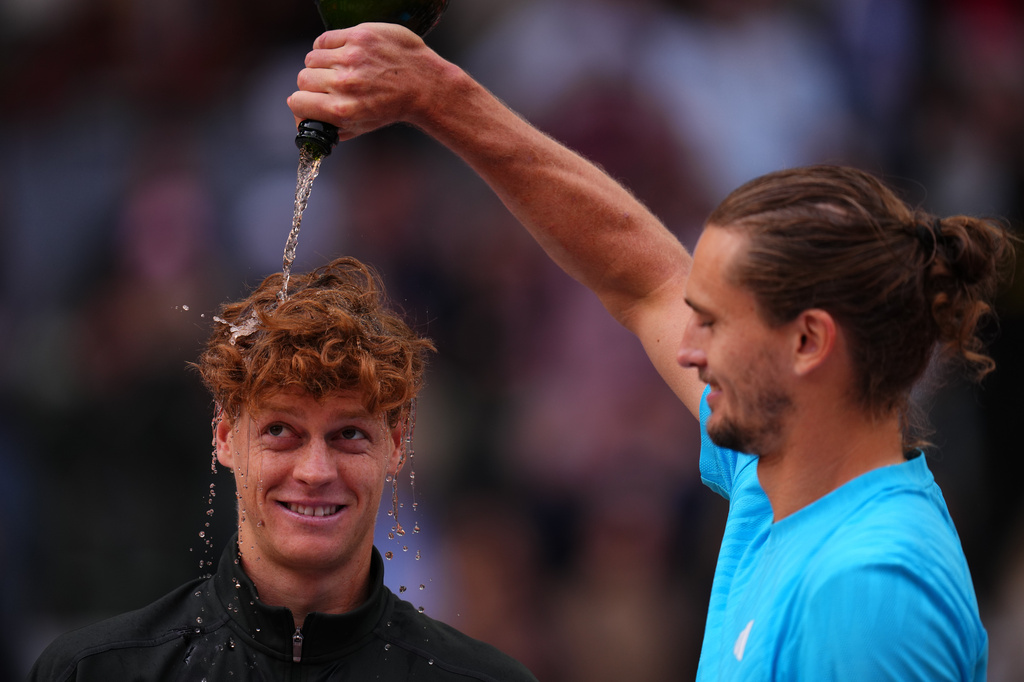 Alexander Zverev, of Germany, right, pours sparkling wine over the head of Jannik Sinner, of Italy, at the end of the men's singles tennis final match against at the Madrid Open tennis tournament in Madrid, Spain, Sunday, May 3, 2026. (AP Photo/Manu Fernandez)
