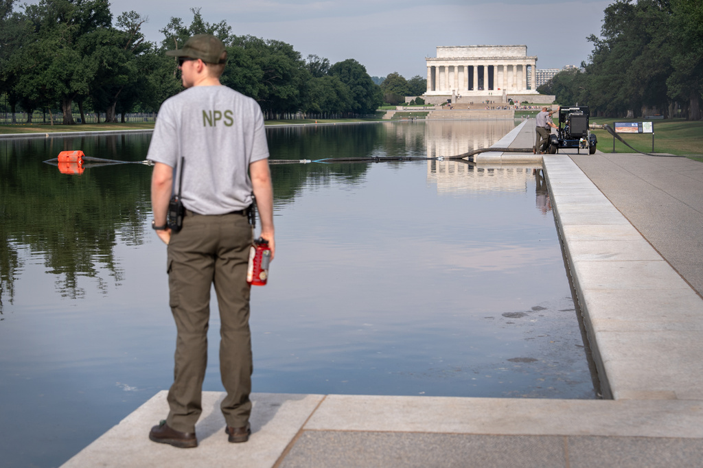 FILE - A National Park Service worker stands near a pump placed next to the Lincoln Memorial Reflecting Pool in Washington, July 10, 2026. (AP Photo/Mark Schiefelbein, File)