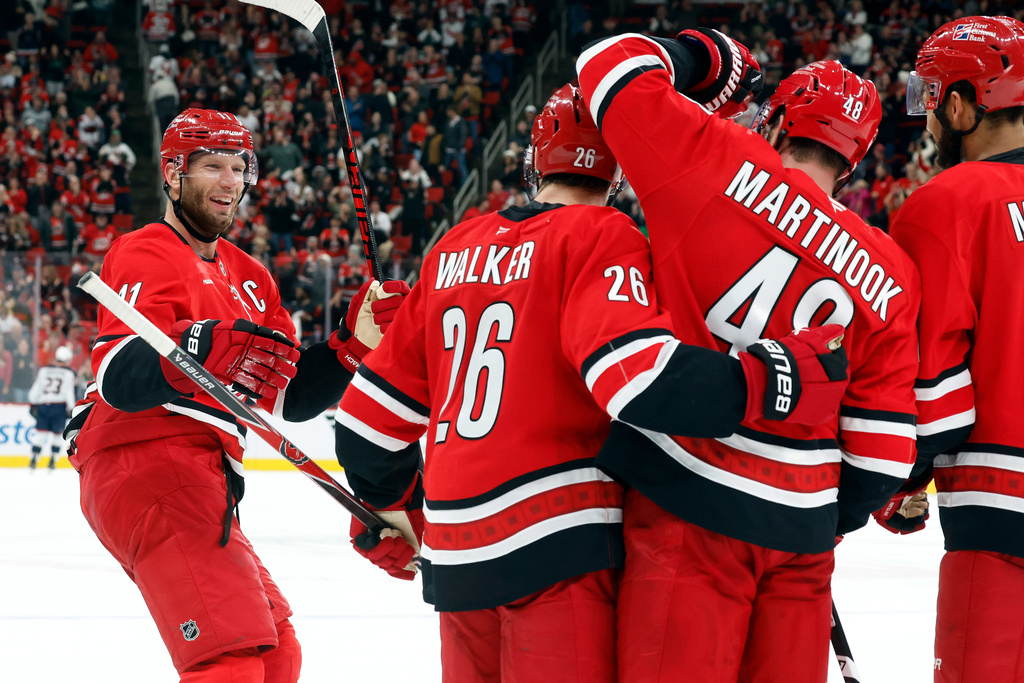 Carolina Hurricanes' Jordan Staal (11) joins the celebration on an empty net goal by Jordan Martinook (48) with Sean Walker (26) and K'Andre Miller (19) nearby during the third period of an NHL hockey game against the Columbus Blue Jackets in Raleigh, N.C., Tuesday, Dec. 9, 2025. (AP Photo/Karl DeBlaker)