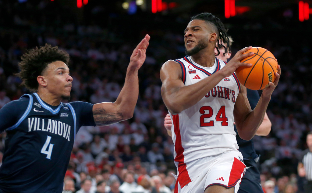 Villanova guard Tyler Perkins, left, defends St. John's forward Zuby Ejiofor during the second half of an NCAA college basketball game Saturday, Feb. 28, 2026, in New York. (AP Photo/John Munson)