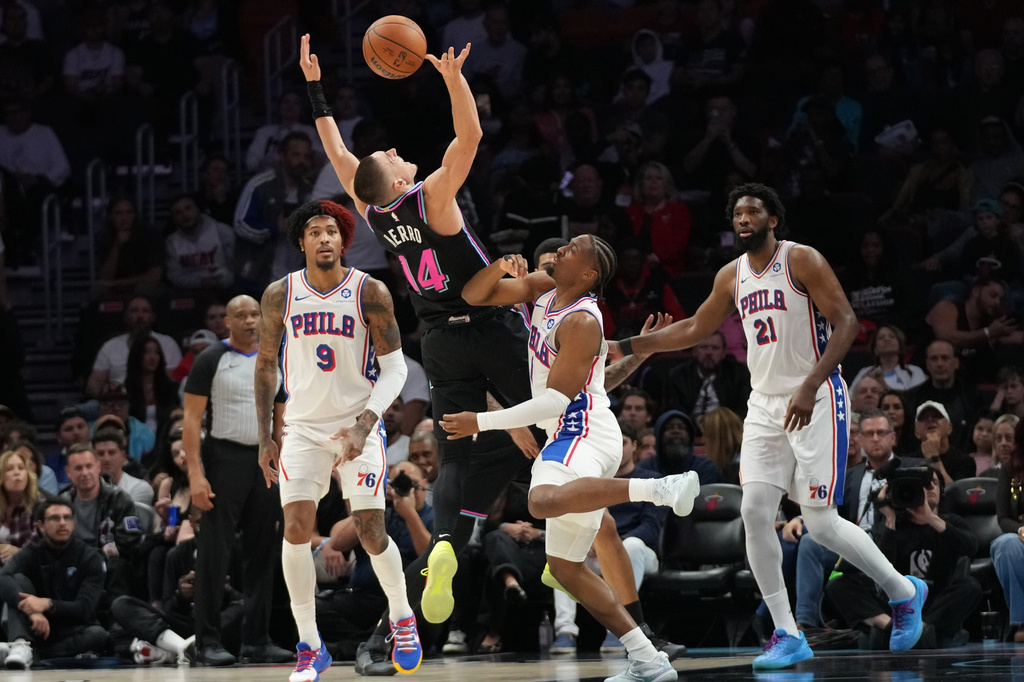 Miami Heat guard Tyler Herro (14) loses control of the ball as Philadelphia 76ers guard Tyrese Maxey, center, defends during the first half of an NBA basketball game, Monday, March 30, 2026, in Miami. (AP Photo/Lynne Sladky)