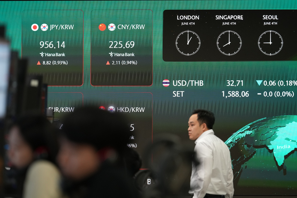 A dealer walks past near the screens showing the foreign exchange rates at a dealing room of Hana Bank in Seoul, South Korea, Thursday, June 4, 2026. (AP Photo/Lee Jin-man)