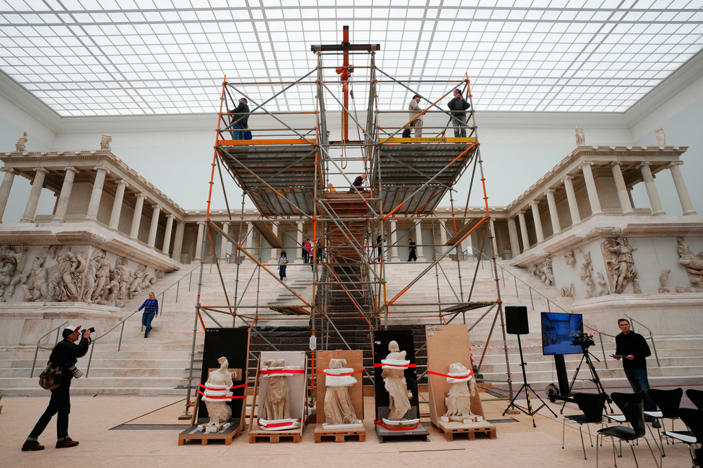 FILE - Journalists look at the Great Altar of Pergamon, during a press tour of the renovation construction site of the Pergamon Museum in Berlin, Germany, Dec. 4, 2025. (AP Photo/Markus Schreiber, File)