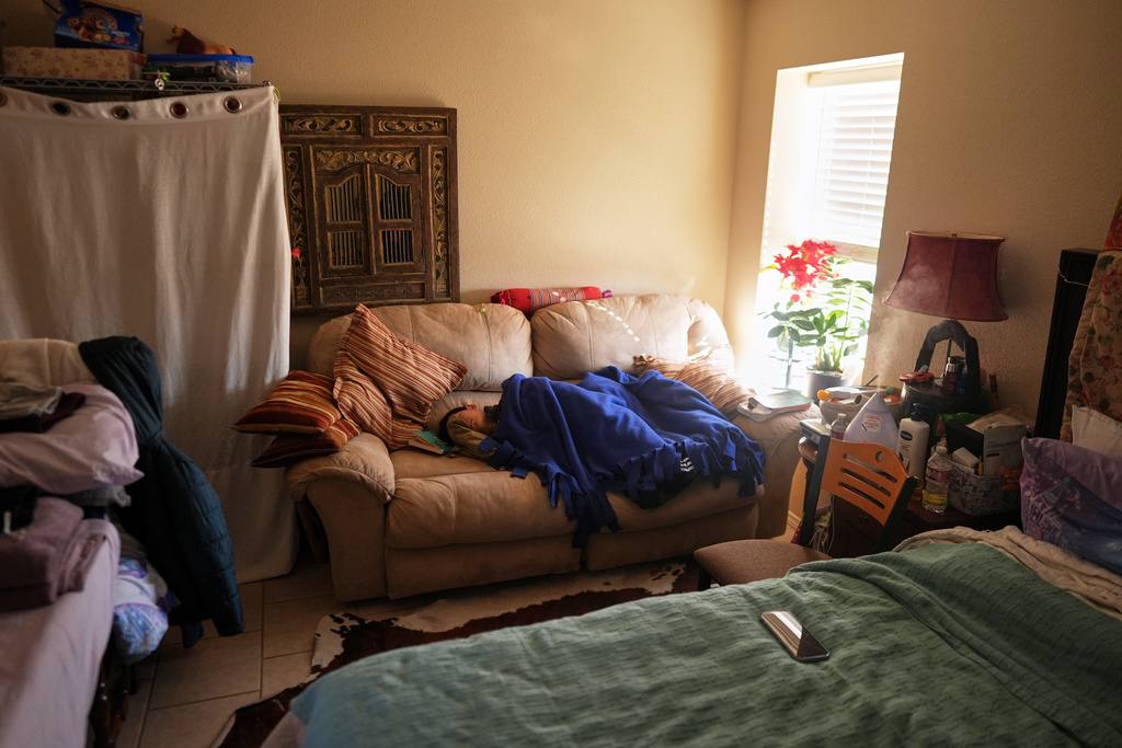 The son of Mayflower Church Deacon, Luo Changcheng, who wasn't feeling well, naps in the room he shares with his parents, in Midland, Texas, Jan. 20, 2025. (AP Photo/Rebecca Blackwell)