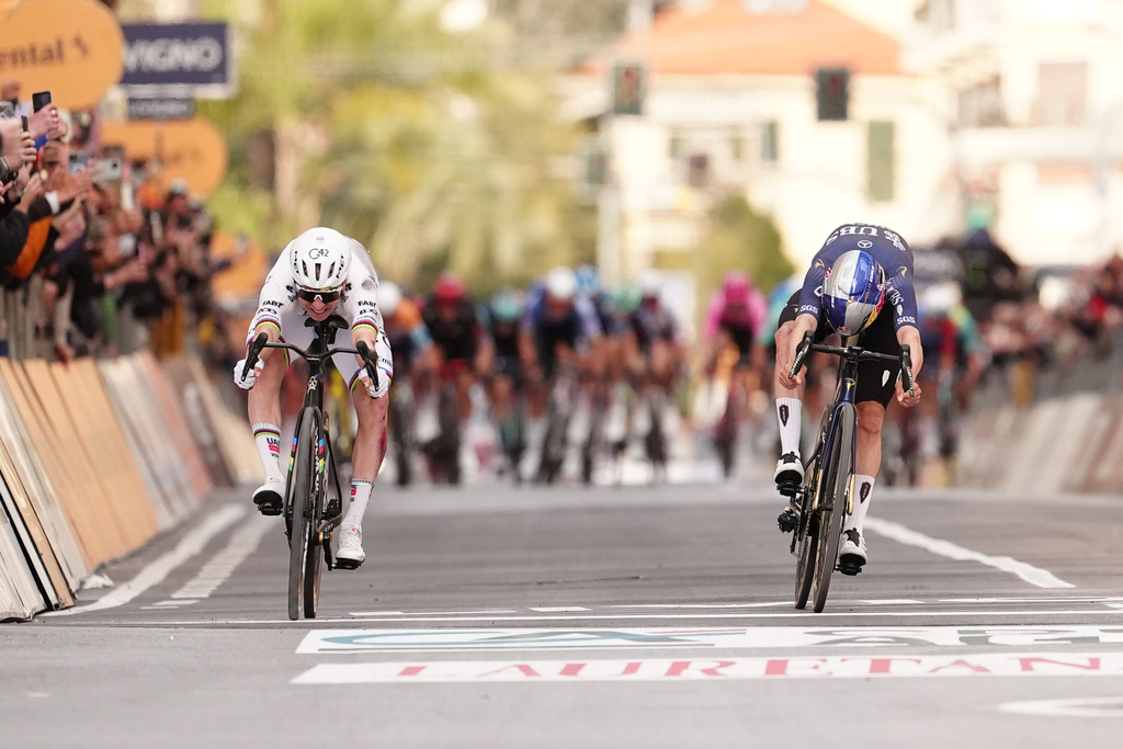 Slovenia's Tadej Pogacar of UAE Team Emirates XRG, left, crosses the finish line ahead of Britain's Thomas Pidcock of Pinarello-Q36.5 Pro Cycling Team, right, to win the men's elite race of the Milano-Sanremo one day cycling race (298 km) from Pavia to Sanremo, Italy, March 21, 2026. (Massimi Paolone/LaPresse via AP)
