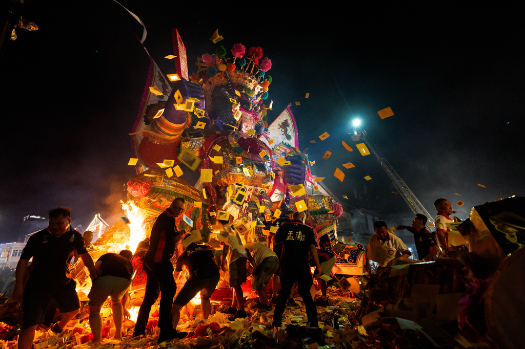 Ethnic Chinese devotees throw paper offerings into a fire during the Hungry Ghost Festival in Bukit Metajam, Malaysia, Saturday, Aug. 29, 2026. (AP Photo/Vincent Thian)