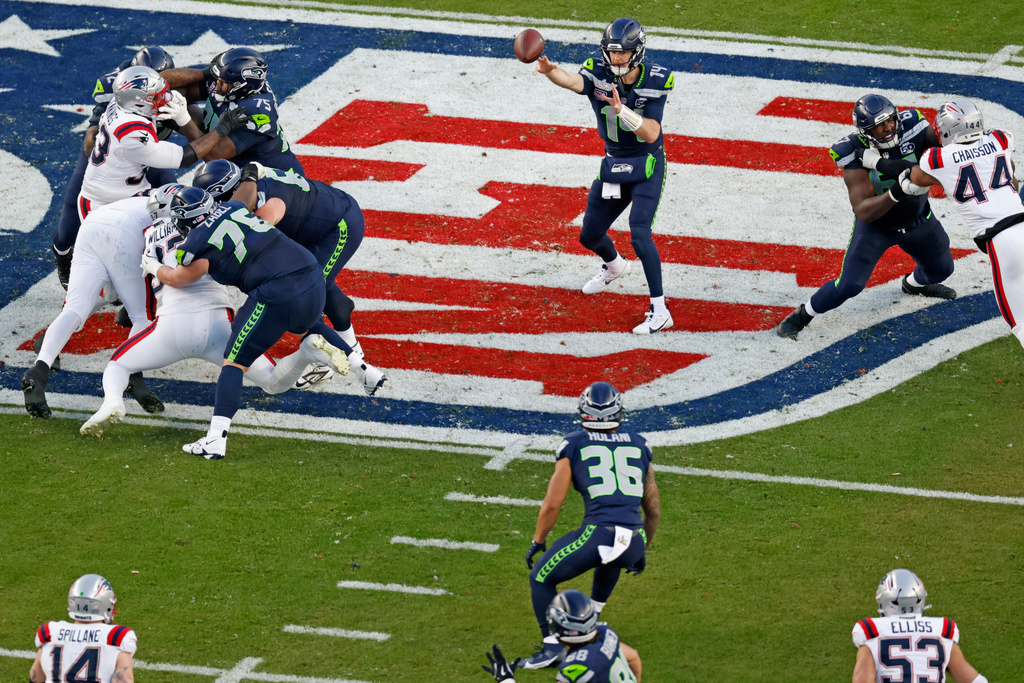 Seattle Seahawks quarterback Sam Darnold (14) completes a pass to Seahawks running back George Holani (36) against the New England Patriots in the second quarter of the NFL Super Bowl 60 football game in Santa Clara, Calif., Sunday, Feb. 8, 2026. (Santiago Mejia/San Francisco Chronicle via AP)