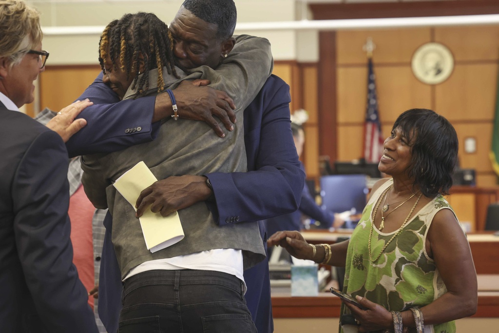 Jamon Kemp, center left, and his father, former Seattle Sonic basketball player Shawn Kemp, embrace after Shawn's sentencing hearing at Pierce County Superior Court in Tacoma, Wash., Friday, Aug. 22, 2025. (Ivy Ceballo/The Seattle Times via AP)