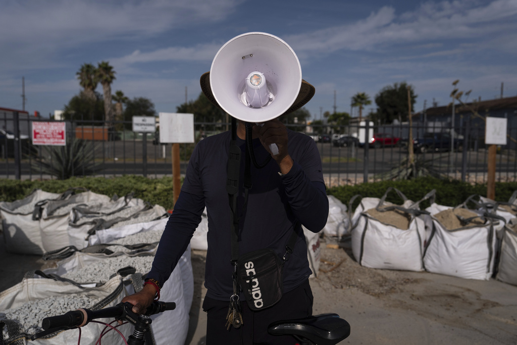 Luis poses with a megaphone used to alert other day laborers of ICE operations in the parking lot of a Home Depot in the Van Nuys section of Los Angeles, Aug. 28, 2025. (AP Photo/Jae C. Hong)