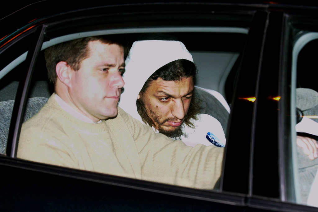 FILE - An FBI agent, left, sits next to a suspect identified by authorities as Richard Reid as he is transported in a car from State Police barracks at Logan International Airport in Boston, Dec. 22, 2001. (AP Photo/Elise Amendola, File)