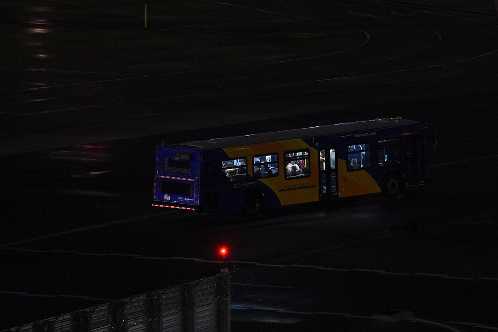 A Port Authority bus drives on the tarmac carrying people from the site where an Air Canada jet collided with a Port Authority flight rescue and firefighting truck at LaGuardia Airport, Monday, March 23, 2026, in New York. (AP Photo/Ryan Murphy)