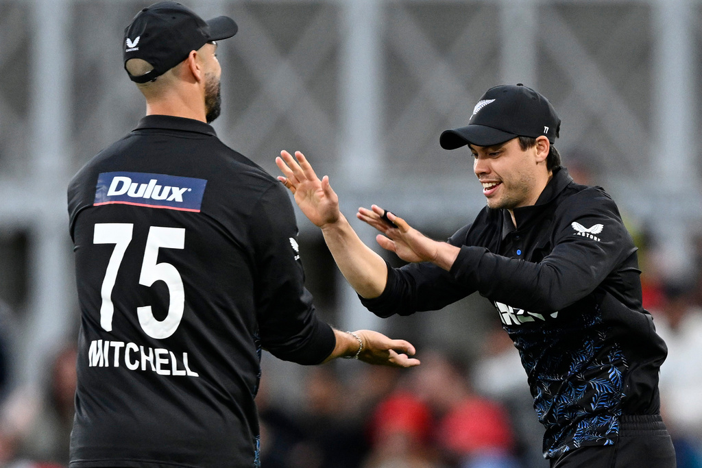 New Zealand's Mark Chapman, right, is congratulated by teammate Daryl Mitchell after taking a catch to dismiss England's Phil Salt during the T20 cricket international between New Zealand and England in Christchurch, New Zealand, Saturday, Oct.18, 2025. (Andrew Cornaga/Photosport via AP)