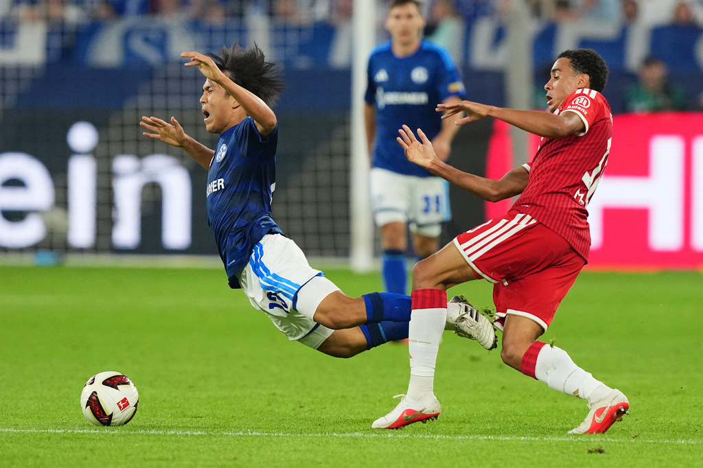 Bayern's Jamal Musiala, right, fouls Schalke's Satoshi Tanaka during the German Bundesliga soccer match between FC Schalke 04 and Bayern Munich in Gelsenkirchen, Germany, Saturday, Sept. 5, 2026. (AP Photo/Martin Meissner)
