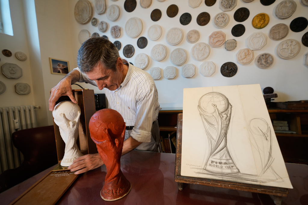 Giorgio Gazzaniga, son of the late sculptor Silvio Gazzaniga, inserts the original plaster World Cup trophy sculpture into a wooden case at a warehouse in Pioltello, Italy, Saturday, July 11, 2026. (AP Photo/Luca Bruno)