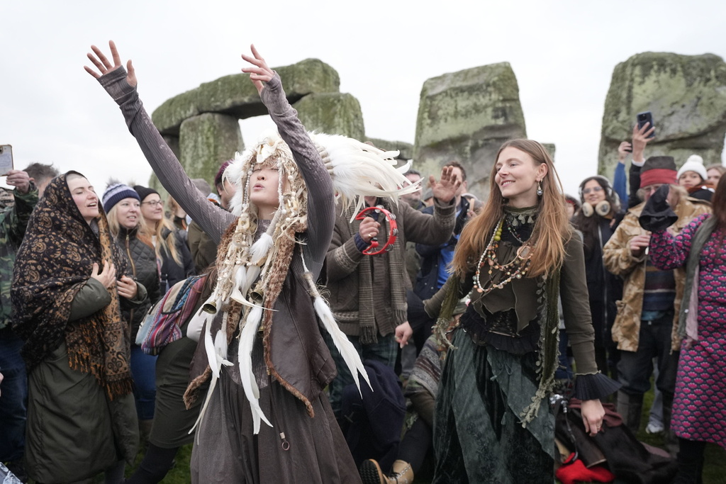 People take part in the winter solstice celebrations during sunrise at the Stonehenge prehistoric monument on Salisbury Plain in Wiltshire, England, Sunday, Dec. 21, 2025. (Andrew Matthew/PA via AP)