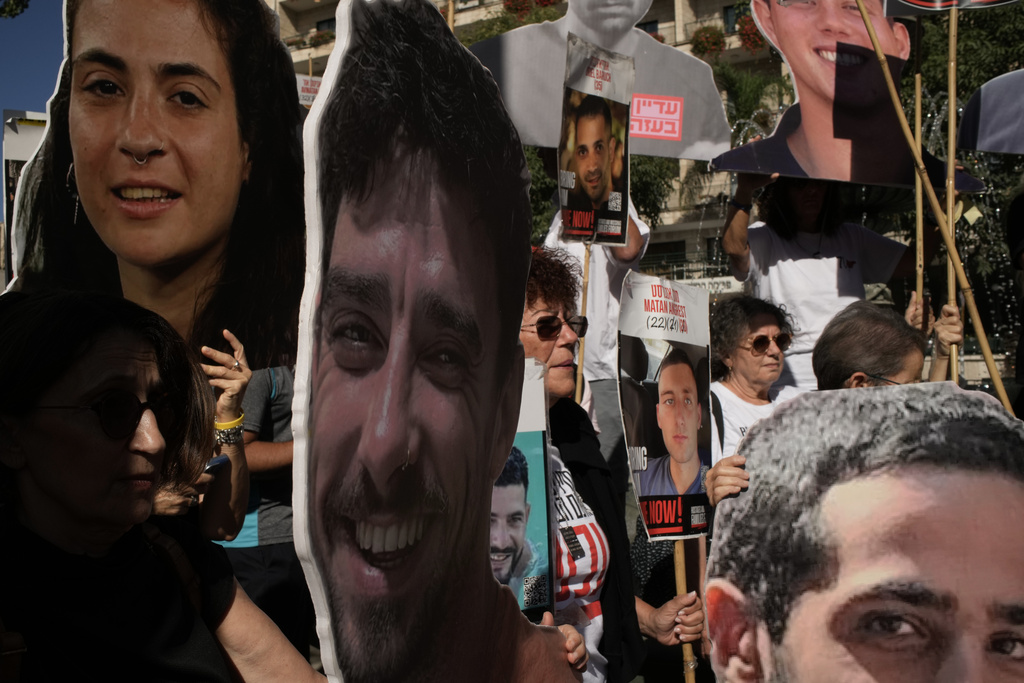 Relatives and supporters of Israeli hostages held by Hamas in the Gaza Strip carry posters with portraits of their loved ones during a protest demanding their immediate release and calling for a ceasefire, in Jerusalem, Tuesday, Oct. 7, 2025, on the second anniversary of Hamas' cross-border attack on Israel on Oct. 7, 2023, which sparked the ongoing war in Gaza. (AP Photo/Leo Correa)