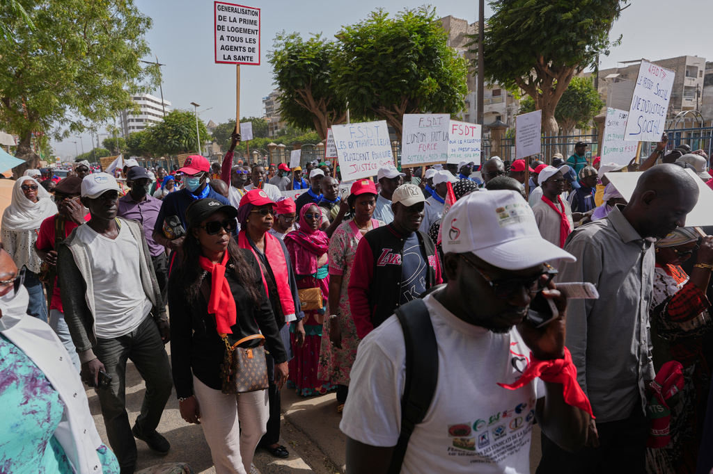 Workers hold placards as they march to demand that the government honor its commitments and address their concerns in Dakar, Senegal, Wednesday, April 8, 2026. (AP Photo/Misper Apawu)