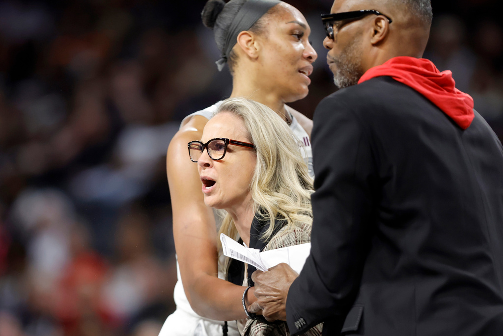 Las Vegas Aces head coach Becky Hammon is held back by Las Vegas Aces center A'ja Wilson and assistant coach Larry Lewis after being ejected during the first half of a WNBA basketball game between the Las Vegas Aces and the Atlanta Dream Tuesday, Aug. 18, 2026, in Las Vegas. (Steve Marcus/Las Vegas Sun via AP) CORRECTION: assistant coach Larry Lewis is correct instead of Tyrone Ellis