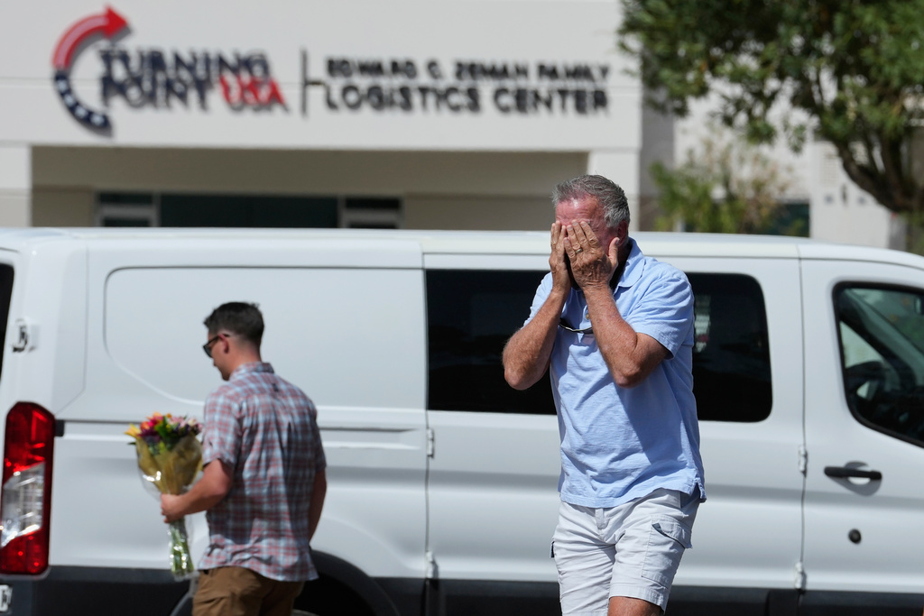 A well-wisher is overcome after dropping off flowers, Wednesday, Sept. 10, 2025, at the national headquarters of Turning Point USA in Phoenix, following the shooting death of Charlie Kirk, the 31-year-old CEO of the organization, at a Utah college. (AP Photo/Ross D. Franklin)