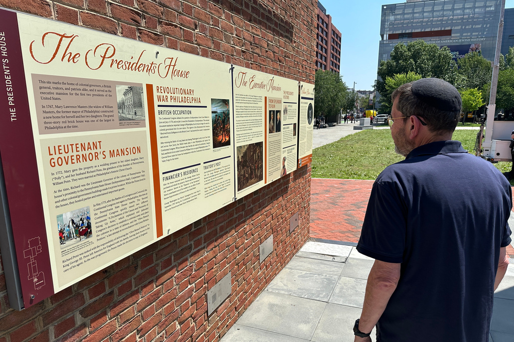 Visitors view the reinstalled educational panels about slavery at the site of President George Washington's home in Philadelphia, Wednesday, July 15, 2026. (AP Photo/Tassanee Vejpongsa)