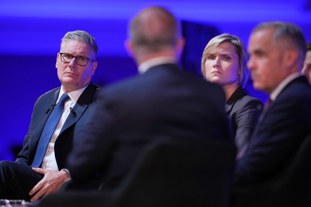 Britain's Prime Minister Keir Starmer, left, listens during a pannel discussion during the Progress Global Action Summit, in London, Friday, Sept. 26, 2025, second right is Iceland Prime Minister Kristrún Mjöll Frostadóttir, and at right is Canadian Prime Minister Mark Carney. (AP Photo/Kin Cheung)
