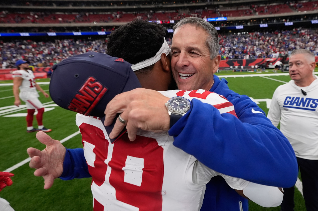New York Giants head coach John Harbaugh, front right, celebrates with Tyrone Tracy Jr., left, after an overtime win over the Houston Texans in an NFL football game in Houston, Sunday, Oct. 25, 2026. (AP Photo/Gerald Herbert)