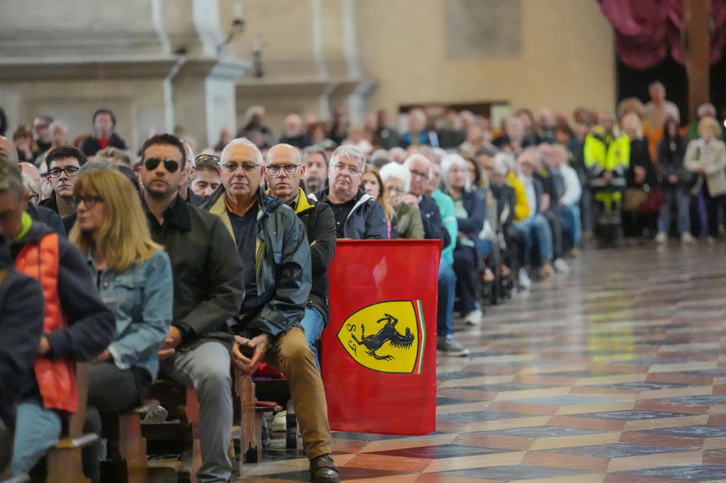 A Ferrari flag is displayed as people attend the funeral of Alex Zanardi, Italian auto racing champion-turned-Paralympic gold medalist, inside the Basilica of Santa Giustina, Padua, Italy, Tuesday, May 5, 2026. (Claudio Furlan/LaPresse via AP)
