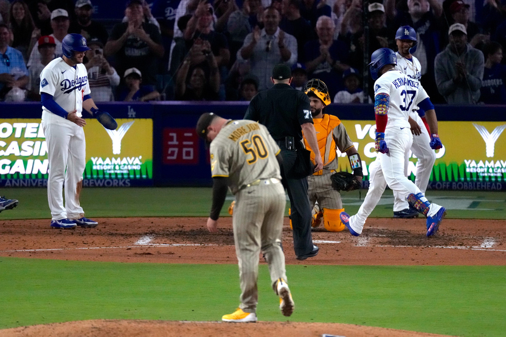 Los Angeles Dodgers' Teoscar Hernández, right, scores hits a grand slam as Max Muncy, left, waits for him as San Diego Padres pitcher Adrian Morejon stands on the mound during the seventh inning of a baseball game Friday, July 3, 2026, in Los Angeles. (AP Photo/Mark J. Terrill)