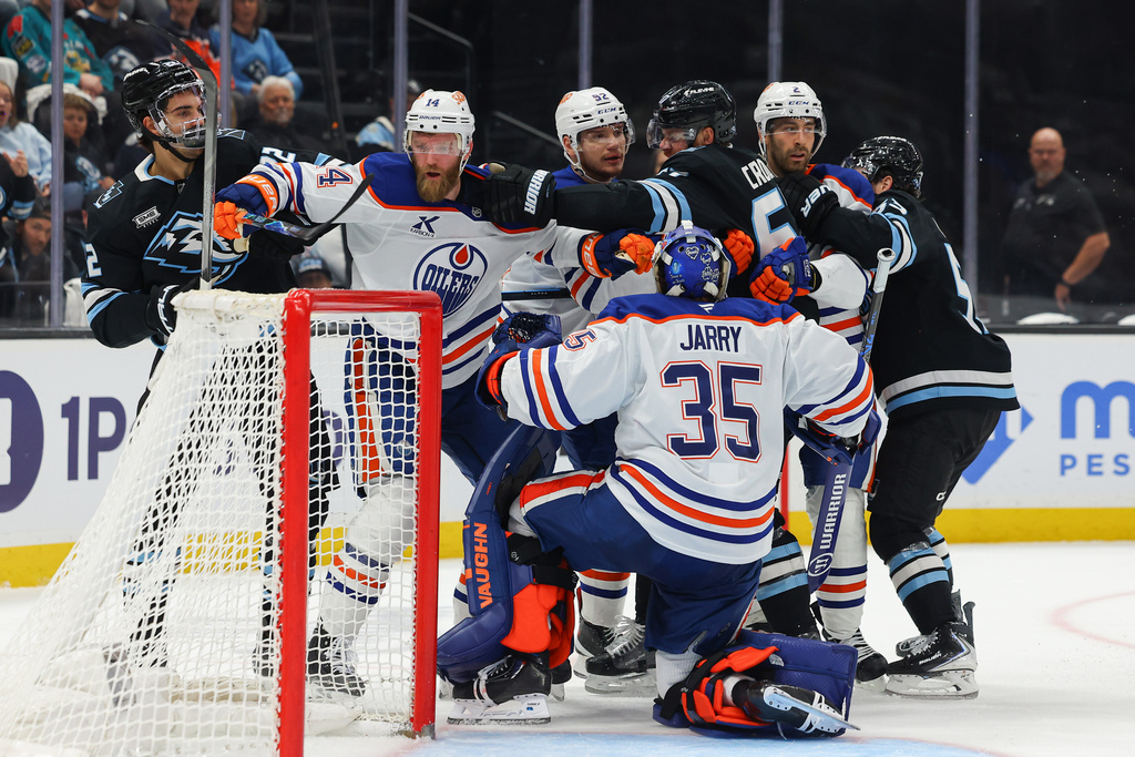 Utah Mammoth center Jack McBain (22) and left wing Lawson Crouse (67) get into a fight against the Edmonton Oilers defenseman Mattias Ekholm (14), right wing Vasily Podkolzin (92) and defenseman Evan Bouchard (2) during the second period of an NHL hockey game, Tuesday, March 24, 2026, in Salt Lake City. (AP Photo/Melissa Majchrzak)