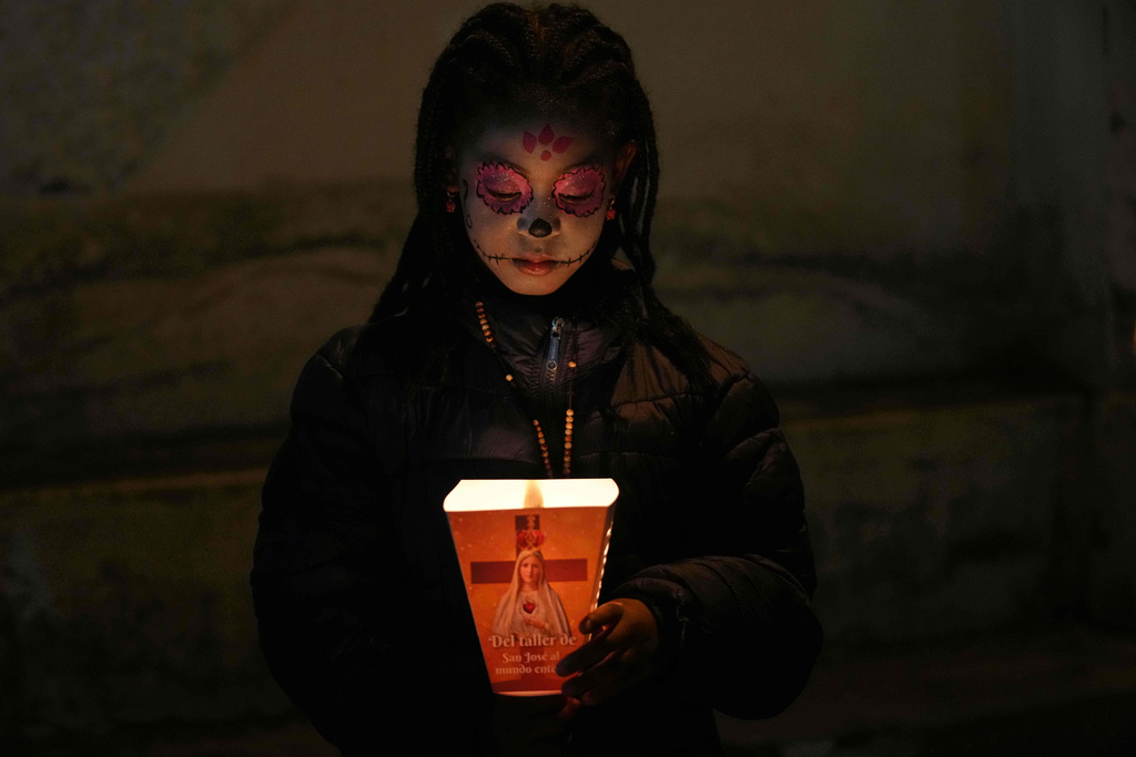 A woman takes part in a Day of the Dead procession in Quito, Ecuador, Saturday, Nov. 1, 2025. (AP Photo/Dolores Ochoa)
