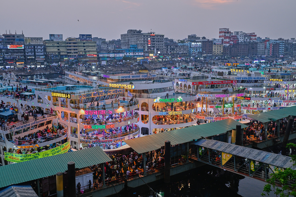 Thousands of travelers scramble to board ferries at the Sadarghat Launch Terminal, joining the massive annual exodus to celebrate Eid al-Fitr in their hometowns, in Dhaka, Bangladesh, Wednesday, March 18, 2026. (AP Photo/Mahmud Hossain Opu)