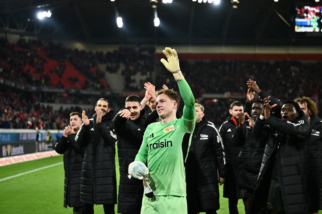 Union Berlin goalkeeper Matheo Raab, center, celebrates with his teammates after winning a German Bundesliga soccer match against SC Freiburg in Freiburg, Germany, Sunday, March 15, 2026. (Silas Stein/dpa via AP)