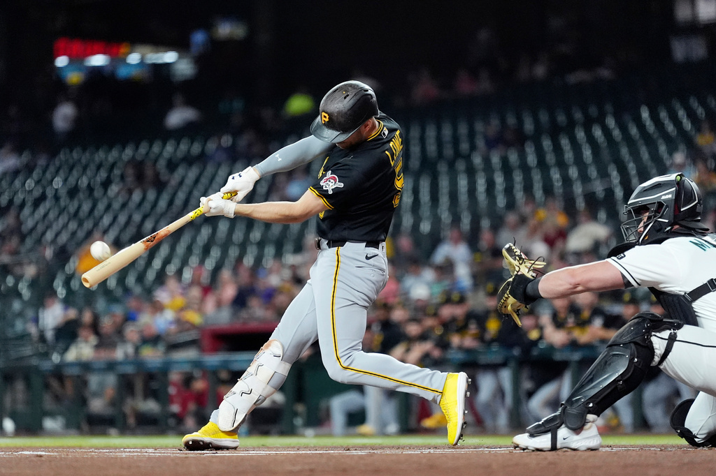 Pittsburgh Pirates' Brandon Lowe, left, connects for a home run as Arizona Diamondbacks catcher James McCann reaches for the ball during the first inning of a baseball game, Thursday, May 7, 2026, in Phoenix. (AP Photo/Ross D. Franklin)