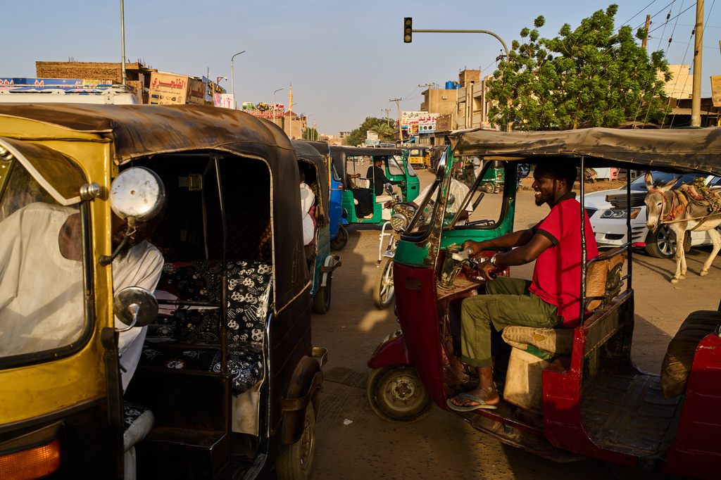 Tuk-tuk drivers cross an intersection in Omdurman, Sudan, on the outskirts of Khartoum, Tuesday, April 21, 2026. (AP Photo/Bernat Armangue)