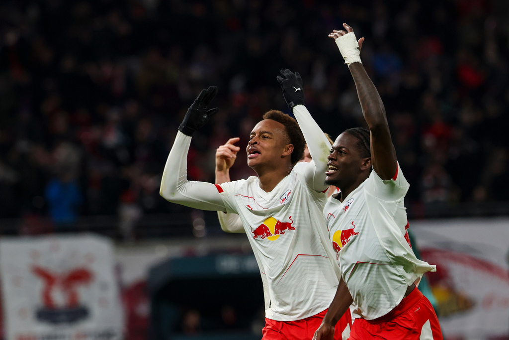 Leipzig's scorer Assan Ouedraogo, left, and Castello Lukeba, right, celebrate the opening goal during the German Bundesliga Soccer match between RB Leipzig and Werder Bremen in Leipzig, Germany, Sunday, Nov. 23, 2025. (Jan Woitas/dpa via AP)