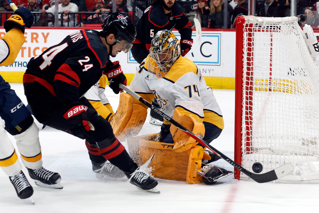 Carolina Hurricanes' Seth Jarvis (24) tries to shoot the puck past Nashville Predators goaltender Juuse Saros (74) during the second period of an NHL hockey game in Raleigh, N.C., Saturday, Dec. 6, 2025. (AP Photo/Karl DeBlaker)