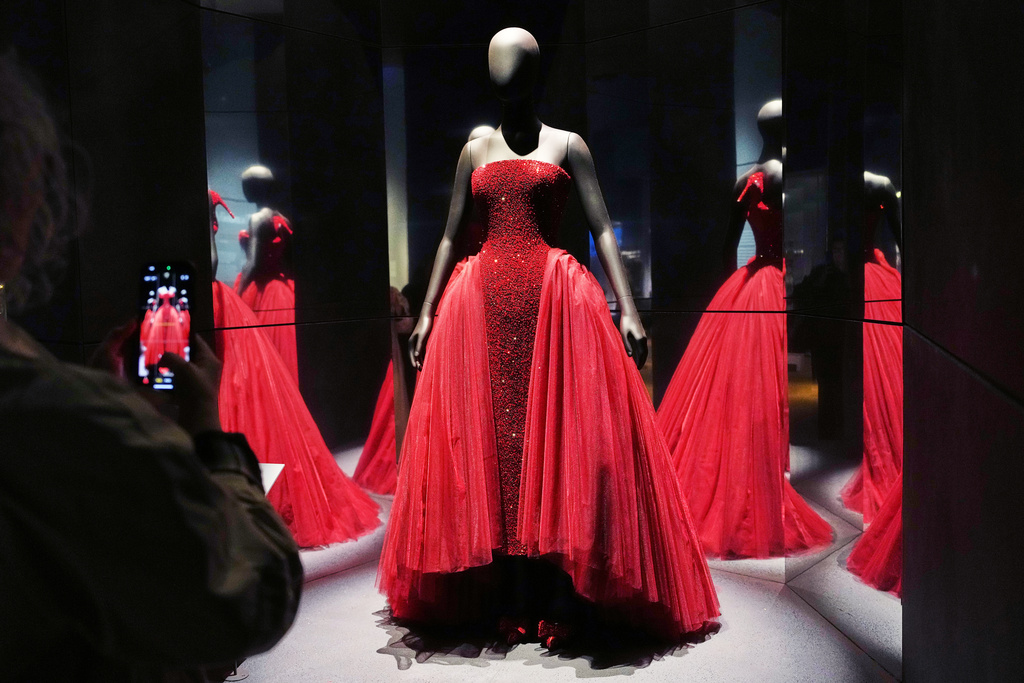 A visitor takes a picture of a gown worn by Ariana Grande at the 2025 Oscars, during the press preview for Schiaparelli: Fashion Becomes Art exhibition at the V&A museum in London, Wednesday, March 25, 2026. (AP Photo/Kirsty Wigglesworth)