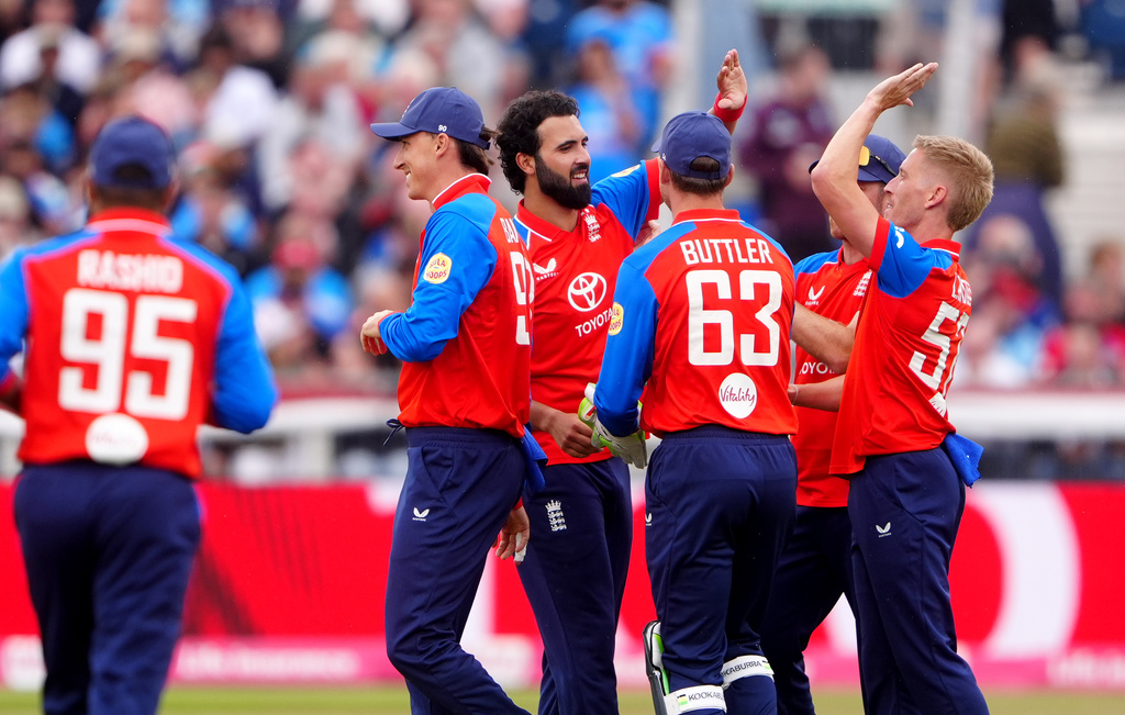 England's Saqib Mahmood, center, celebrates with his teammates after taking the wicket of India's Sanju Samson during the first IT20 cricket match at Chester-le-Street, England, Wednesday July 1, 2026. (Owen Humphreys/PA via AP)