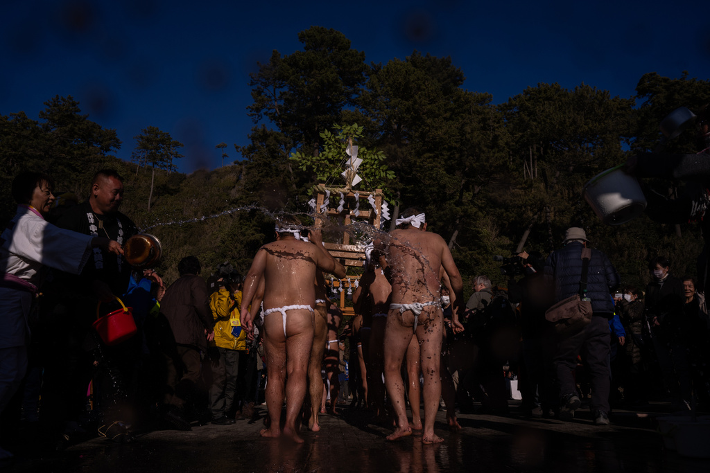 Participants carry a portable shrine 'mikoshi', during the Winter Sea Misogi Festival, a Shinto purification ritual marking the New Year, in Numazu, Japan, Monday, Jan. 12, 2026. (AP Photo/Louise Delmotte)