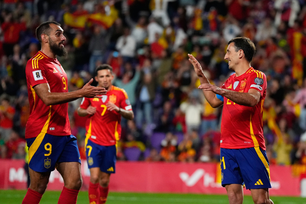 Spain's Mikel Oyarzabal, right, celebrates with Spain's Borja Iglesias, left, after he scored the 4th goal from the penalty spot during the World Cup 2026 group E qualifying soccer match between Spain and Bulgaria in Valladolid, Spain, Tuesday, Oct. 14, 2025. (AP Photo/Manu Fernandez)
