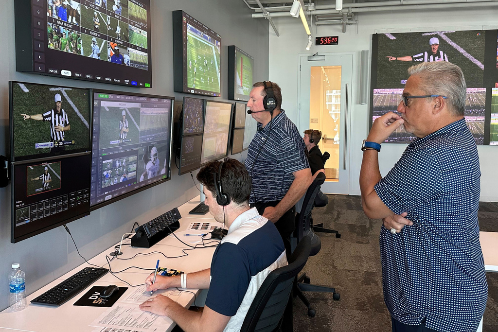 FILE - Alberto Riveron, right, the Atlantic Coast Conference supervisor of football officials, works in the league's new gameday operations center, Saturday, Sept. 2, 2023, in Charlotte, N.C. (AP Photo/Aaron Beard, File)