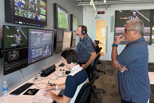 FILE - Alberto Riveron, right, the Atlantic Coast Conference supervisor of football officials, works in the league's new gameday operations center, Saturday, Sept. 2, 2023, in Charlotte, N.C. (AP Photo/Aaron Beard, File) FILE - Alberto Riveron, right, the Atlantic Coast Conference supervisor of football officials, works in the league's new gameday operations center, Saturday, Sept. 2, 2023, in Charlotte, N.C. (AP Photo/Aaron Beard, File)