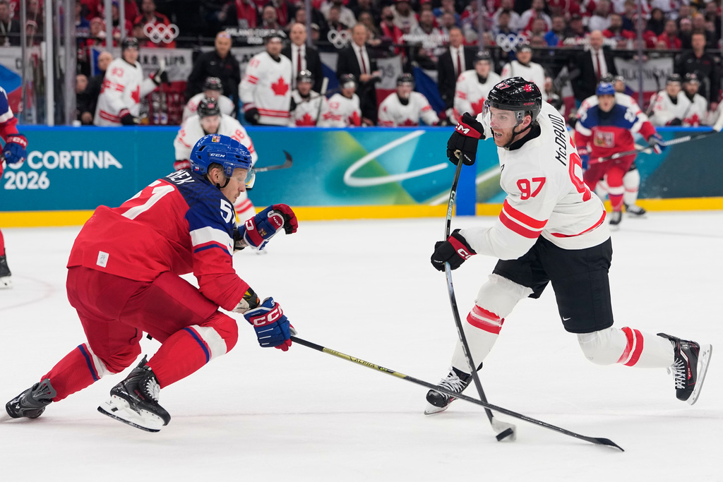 Czechia's Radim Simek tries to block a shot by Canada's Connor McDavid during a preliminary round match of men's ice hockey between Czech Republic and Canada at the 2026 Winter Olympics, in Milan, Italy, Thursday, Feb. 12, 2026. (AP Photo/Petr David Josek)