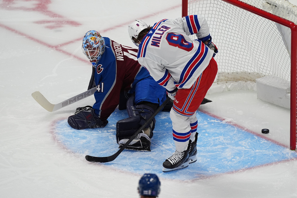 New York Rangers center J.T. Miller, front, redirects the puck past Colorado Avalanche goaltender Scott Wedgewood for a goal in the first period of an NHL hockey game Thursday, Nov. 20, 2025, in Denver. (AP Photo/David Zalubowski)