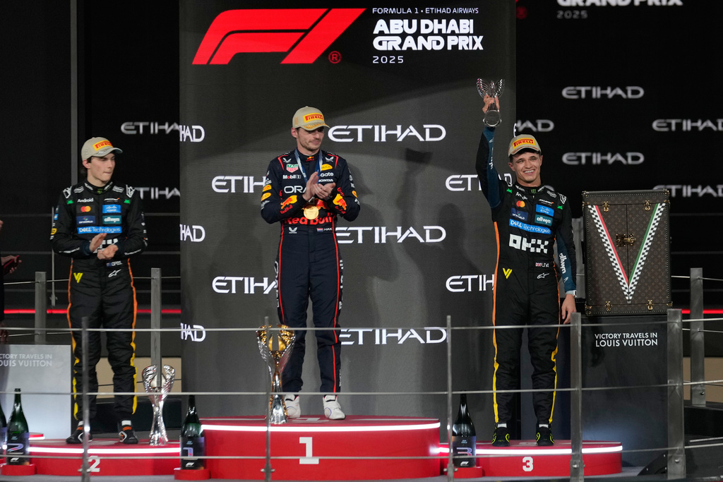 Race winner Red Bull driver Max Verstappen of the Netherlands, center, poses on the podium with second placed McLaren driver Oscar Piastri of Australia, left, and third placed McLaren driver Lando Norris of Britain after the Formula One Abu Dhabi Grand Prix at the Yas Marina Circuit in Abu Dhabi, UAE, Sunday, Dec. 7, 2025. (AP Photo/Altaf Qadri)