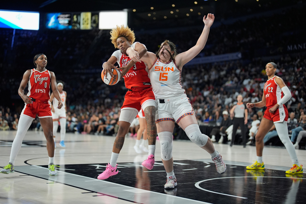 Las Vegas Aces forward NaLyssa Smith (3) and Connecticut Sun forward Raegan Beers (15) battle for the ball during the first half of a WNBA basketball game Thursday, Aug. 20, 2026, in Las Vegas. (AP Photo/John Locher)