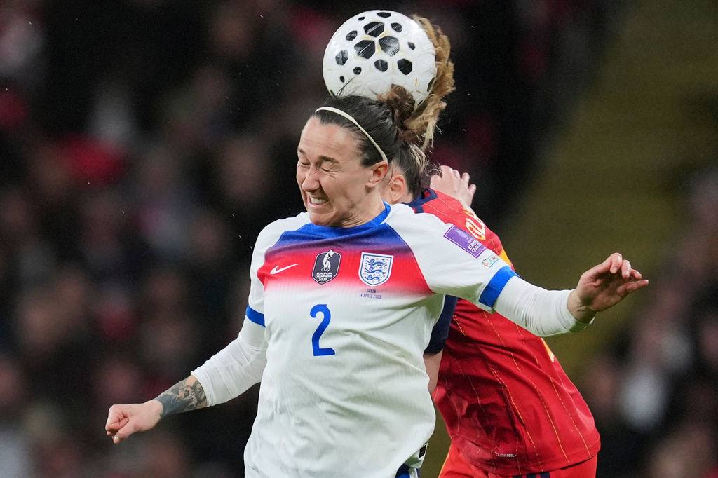 England's Lucy Bronze heads the ball before Spain's Olga Carmona, rear, during the Women's 2027 World Cup group C qualifier soccer match between England and Spain in London, Tuesday, April 14, 2026. (AP Photo/Kin Cheung)