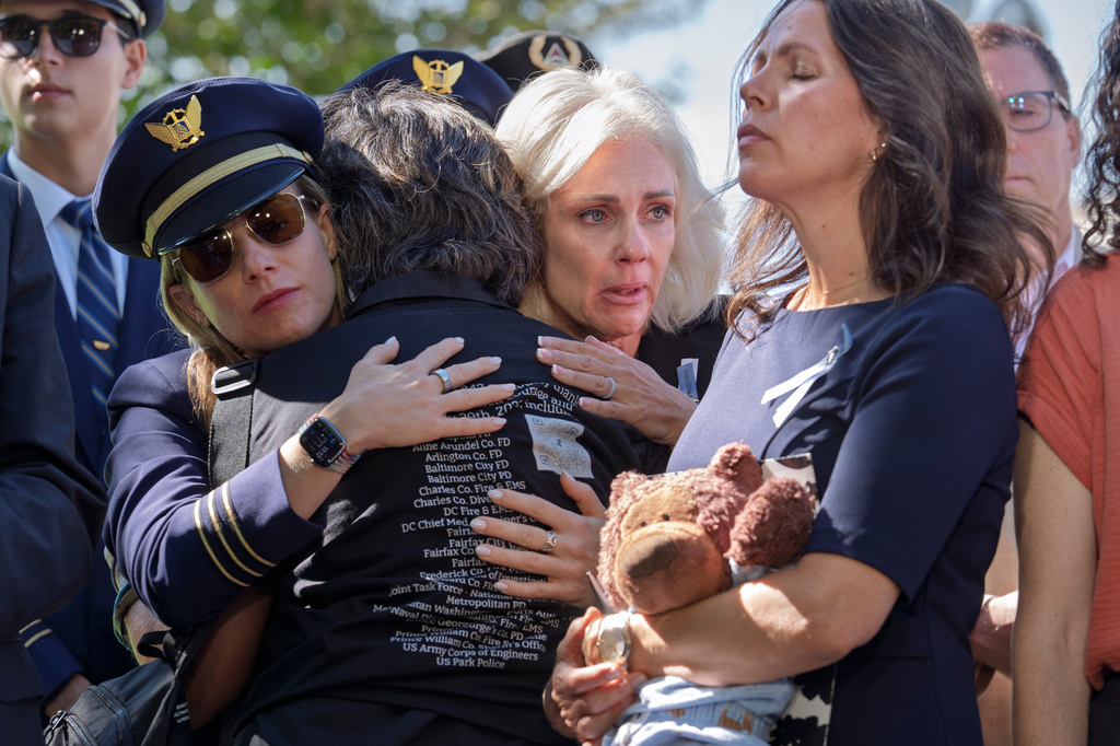 National Transportation Safety Board Chair Jennifer Homendy, center, helps to comfort Christina Stovall, center with back to camera, and Laura Augendre, right, family members of victims of flight 5342, the deadly Jan. 2025 midair collision between an American Airlines plane and a Black Hawk helicopter over the Potomac River, during a news conference on air safety reforms, at the Capitol in Washington, Tuesday, Sept. 15, 2026. (AP Photo/J. Scott Applewhite)