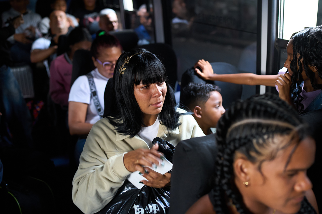 Mileidy Mendoza and her children ride a bus from Caracas to visit her husband, Eric Diaz, imprisoned on political grounds at the Yare prison complex in San Francisco de Yare, Venezuela, Sunday, April 5, 2026. (AP Photo/Ariana Cubillos)