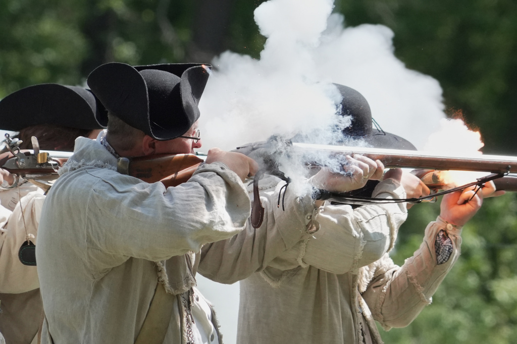 Re-enactors fire a volley with their flintlock muskets during a Revolutionary War event in Halifax, N.C., on April 11, 2026. (AP Photo/Allen G. Breed)